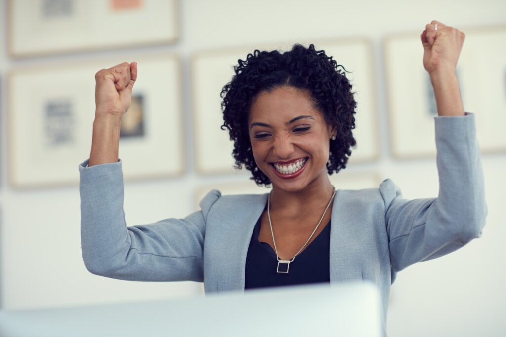 A happy employee celebrating success for her sales and marketing job.