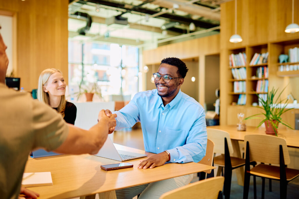 A sales rep shaking hands with a customer as part of his customer-facing role.